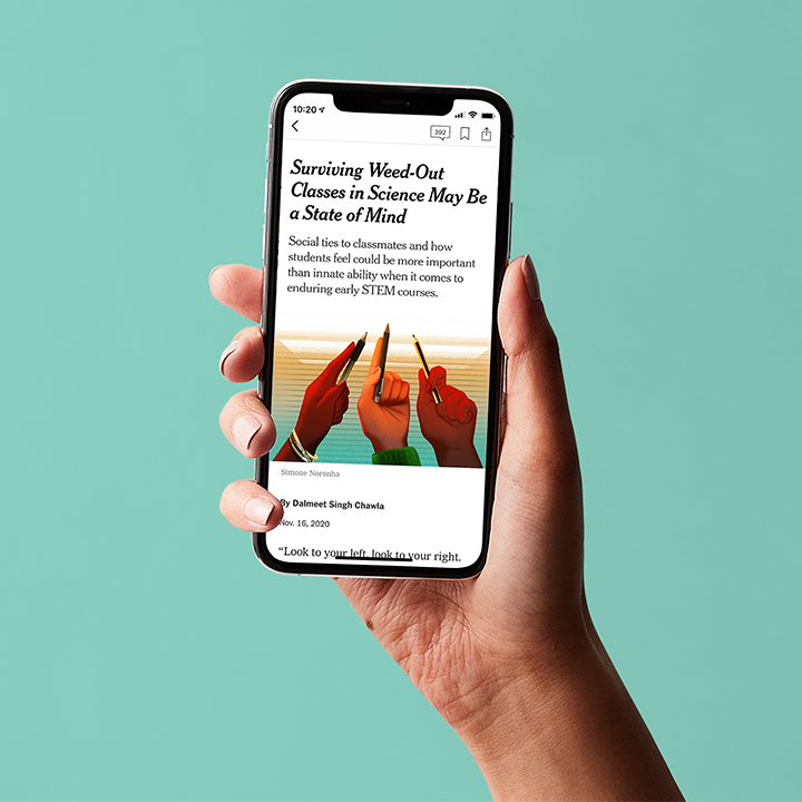 Hand holding a mobile with newspaper site on the screen